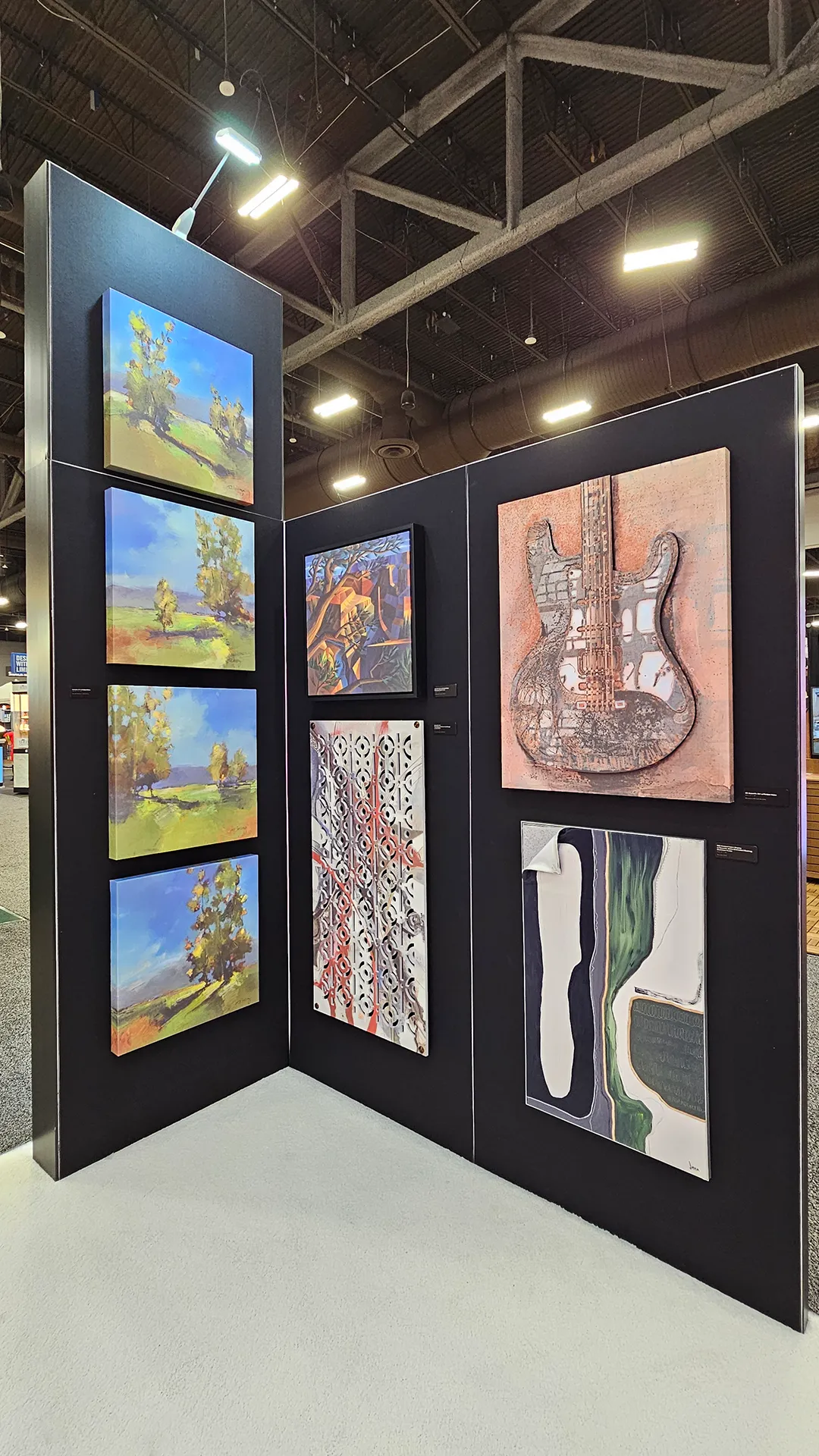 Gallery-style display of custom printed artwork, decorative panels, and textured art pieces featured inside the Image Craft trade show booth.