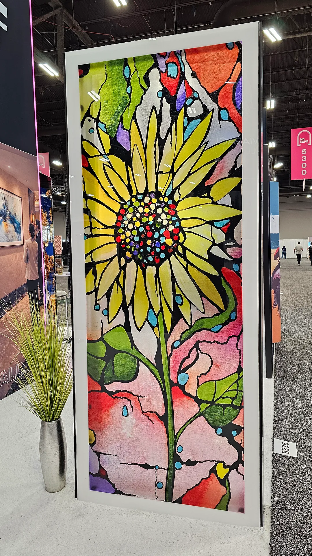 Large-format floral artwork panel featuring a colorful sunflower design displayed at the Image Craft trade show booth.