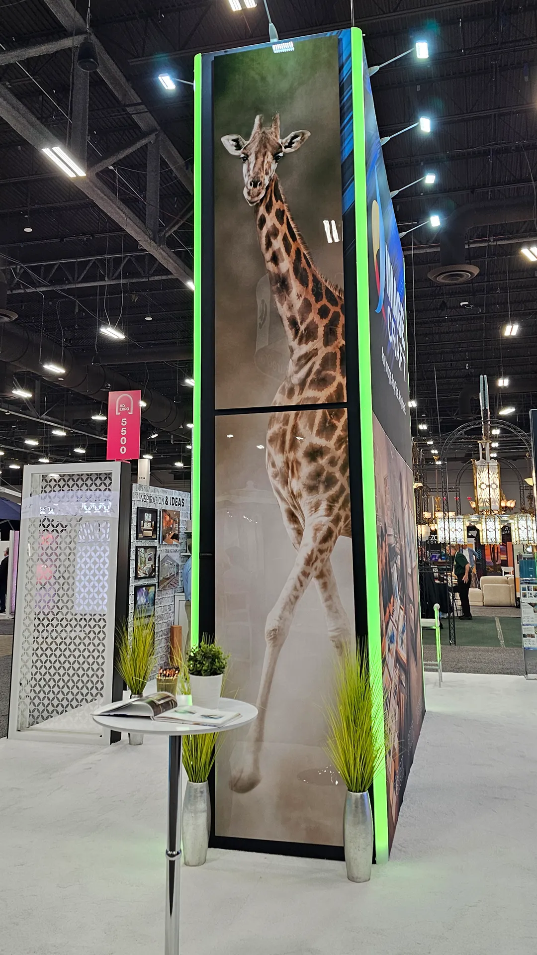 Floor-to-ceiling giraffe artwork printed on a large-format display tower inside the Image Craft trade show booth.
