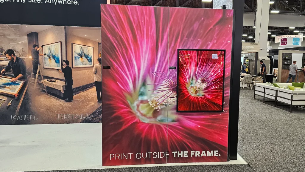 Large-format floral artwork display with layered dimensional print feature and “Print Outside the Frame” branding at the Image Craft trade show booth.
