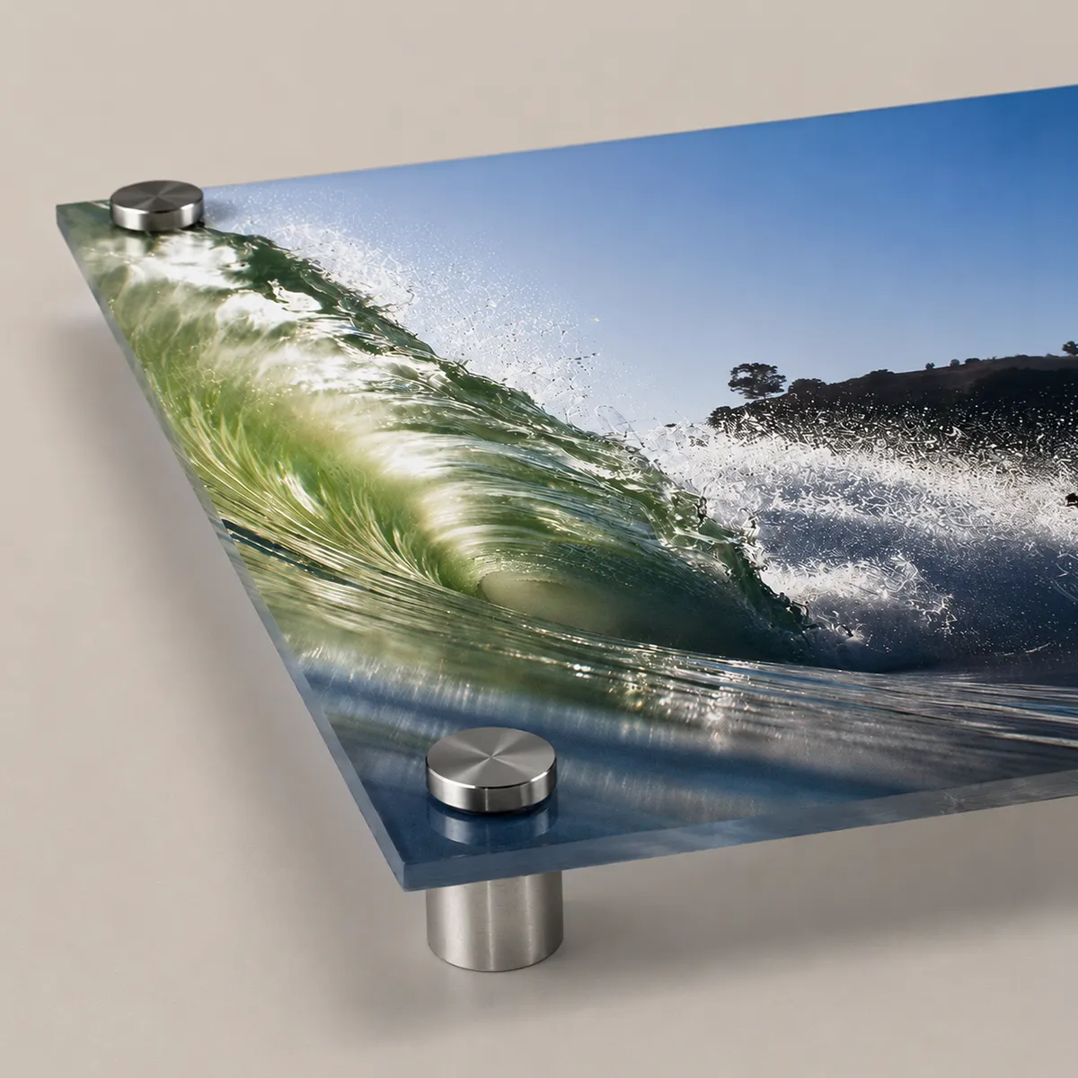Close-up of a vibrant ocean wave photograph printed on acrylic and mounted with polished stainless steel standoffs.