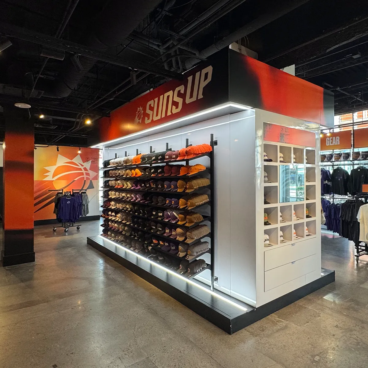 Custom retail graphics and illuminated branded displays inside the Phoenix Suns team shop showcasing apparel and merchandise.