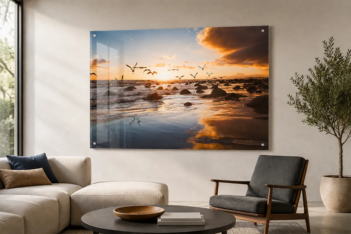 Acrylic wall art featuring an ocean sunset photograph mounted with metal standoffs in a modern living room