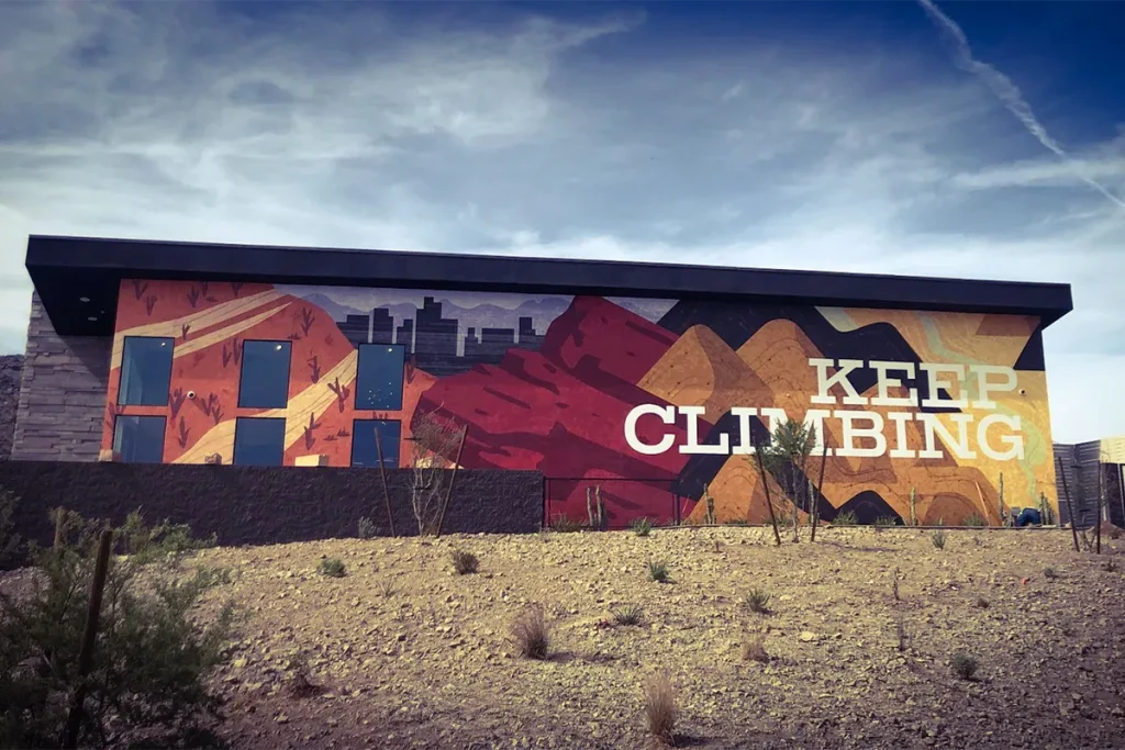 Colorful Keep Climbing exterior wall mural covering a commercial building facade