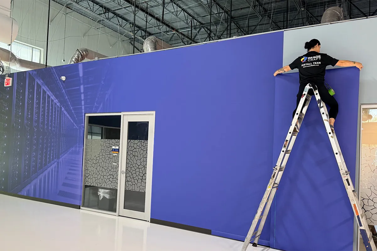 Image Craft installer applying a large custom wall mural in a commercial interior