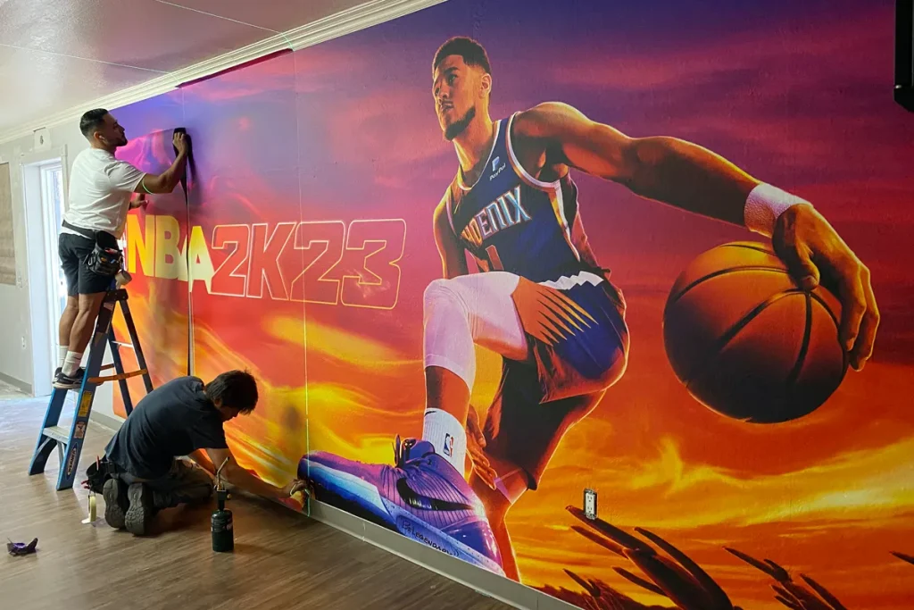 Image Craft installers applying a Phoenix Suns NBA 2K23 custom wall mural